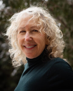 photo of a white woman with light coloured hair looking into the camera and smiling.